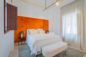 a white bedroom with a white bed and a window at Casa de la Acequia by Florentia Homes in Granada