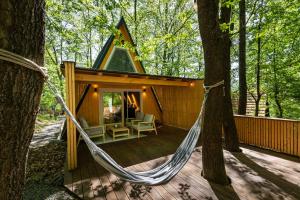 a hammock on the deck of a cabin in the woods at Kabinka Mátra in Pásztó