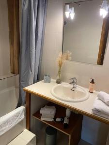 een badkamer met een wastafel, een spiegel en een bad bij Maison cosy proche centre ville in Compiègne
