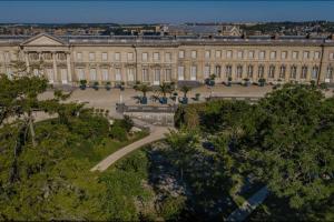 un grand bâtiment avec des arbres devant dans l'établissement Maison cosy proche centre ville, à Compiègne