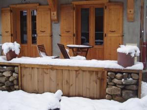 una terraza de madera con nieve en la parte superior en Chalet Rum Doodle en Pralognan-la-Vanoise
