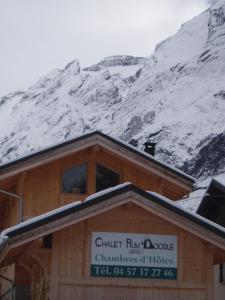 a building with a snow covered mountain in the background at Chalet Rum Doodle in Pralognan-la-Vanoise