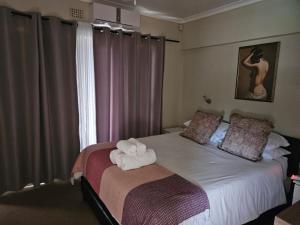 a bedroom with a bed with towels on it at Holiday Home De Villiers in Hermanus