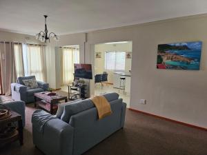 a living room with two couches and a table at Holiday Home De Villiers in Hermanus