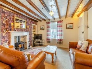 sala de estar con muebles de cuero y chimenea en Esk Dale View, en Grosmont