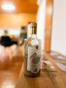 a bottle of wine sitting on a wooden table at Casinha Ponte Nova in Monção