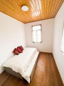 a bedroom with a bed and a wooden ceiling at Casinha Ponte Nova in Monção