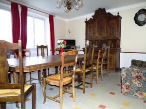 comedor con mesa de madera y sillas en Gite Bellevue 