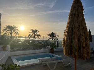 a pool on the roof of a house with the sunset at Pasitoblanco Porto Mare 44 Seaview Villa private heated pool in Pasito Blanco