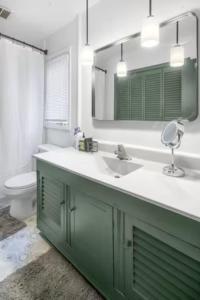 a bathroom with a sink and a mirror and a toilet at 3BR/2BA Lakehouse 10 min to town in Lansing