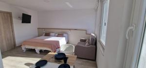 a small bedroom with a bed and a couch at Estudios en Plaza Cabo da Vila centro Muxia in Muxia