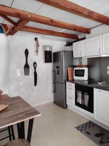 a kitchen with a refrigerator and a table in it at Navajos in Buis-les-Baronnies