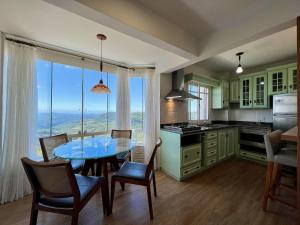 a kitchen with a table and chairs with a view at Apartamento Vale Quilombo 2 dorm by Achei Gramado in Gramado