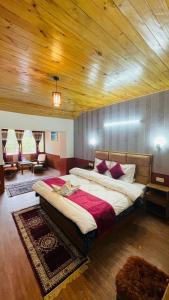 a bedroom with a large bed with a wooden ceiling at Hotel Hilltop At Mall Road Manali With Open Terrace in Manāli