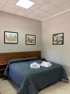 ein Schlafzimmer mit einem Bett mit zwei Handtüchern darauf in der Unterkunft Casa di Aurora in Guidonia