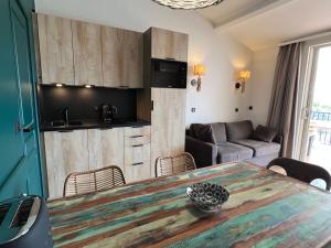 a kitchen and living room with a table and a couch at Les Restanques du Golfe de Saint Tropez in Grimaud