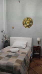 sypialnia z łóżkiem z talerzem na ścianie w obiekcie Oasi del Lago w mieście Regalbuto