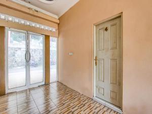an empty room with a door and a wooden floor at OYO 92459 Cahyo Kost 2 in Semarang
