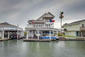 uma casa sobre uma doca sobre um corpo de água em Bayfront Jamaica Beach House Canal Access and Decks em Galveston