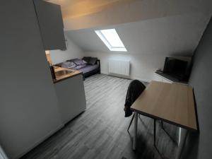 mały pokój z łóżkiem i stołem w obiekcie Studio "Sous les toits", Proche Hyper Centre et Commerces ! w mieście Valenciennes