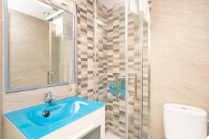 ein Badezimmer mit einem blauen Waschbecken und einem WC in der Unterkunft Suites Bola de Oro in Granada