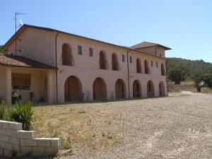 a large building with arched windows and a driveway at Agriturismo Masseria Castiglione in Gallicchio
