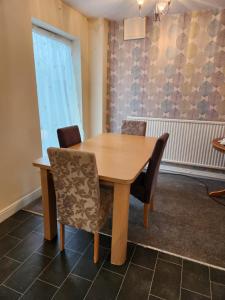 una mesa de madera y sillas en una habitación en Fox Hollies Shared House, en Birmingham