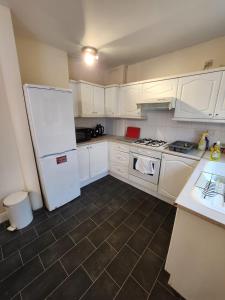 a kitchen with white cabinets and a white refrigerator at Fox Hollies Shared House in Birmingham