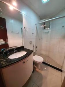 La salle de bains est pourvue d'un lavabo, de toilettes et d'une douche. dans l'établissement Apartamento Completo Frente Praia de Itaparica, à Vila Velha