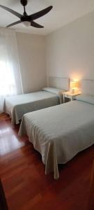 a bedroom with two beds and a ceiling fan at Habitación doble independiente con baño compartido in Granada