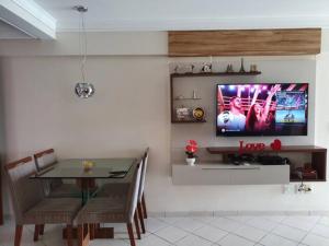 d'une salle à manger avec une table et une télévision murale. dans l'établissement Apartamento Completo Frente Praia de Itaparica, à Vila Velha