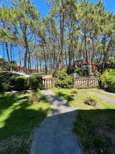 a walkway in a yard with trees and a fence at El Caldén, Mar Azul a 1 cuadra del mar in Mar Azul