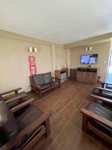 a living room with leather furniture and a flat screen tv at El Caldén, Mar Azul a 1 cuadra del mar in Mar Azul