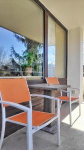 two chairs and a table on a balcony at RELAX - ORANGE mit Pool und Sauna in Sonthofen