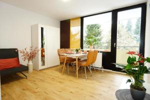 a living room with a table and chairs and windows at RELAX - ORANGE mit Pool und Sauna in Sonthofen