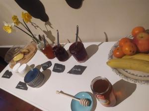 uma mesa branca com frutas e bebidas em Le Manoir de Kérofil ** Gîte et chambres d'hôtes ** 