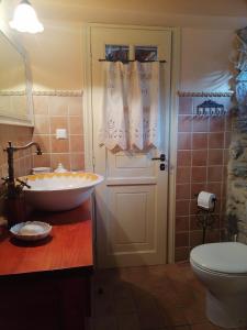 a bathroom with a tub and a sink and a toilet at Large Stone Villa with garden. in Khánia