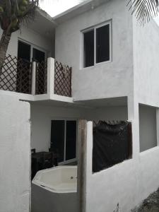 a white house with a balcony and a bath tub at Villas Higuer in Escuintla