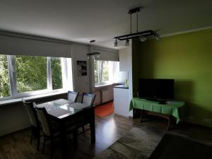 ein Wohnzimmer mit einem Tisch und einer grünen Wand in der Unterkunft Kesklinna silla apartment in Pärnu