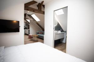 a bedroom with a white bed and a living room at Escapade Eudoise in Eu
