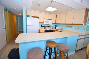 a kitchen with blue and white cabinets and stools at Bay Princess 211 in Ocean City +8 photos