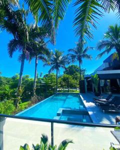 uma piscina numa villa com palmeiras em Pousada Bella Casa em Balneário Camboriú