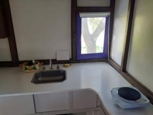 um balcão de cozinha com um lavatório e uma janela em Casa Vagón en las sierras em Tandil