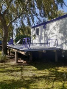 Casa Vagón en las sierras في تانديل: مقطورة تجلس على طاولة بجانب شجرة