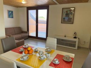 a living room with a dining room table with fruit on it at Perla Top Floor Apartment in Sirmione