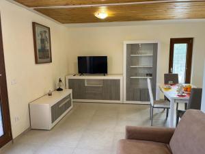 a living room with a table and a tv in it at Perla Top Floor Apartment in Sirmione