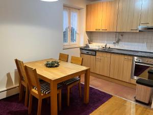 cocina con mesa de madera y sillas en Charmantes Appartement - München en Múnich