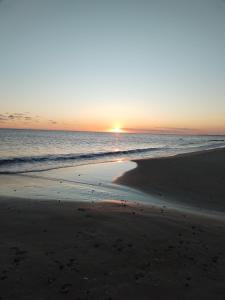 una puesta de sol en una playa con el océano en Unica, en Piriápolis