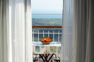 un tazón de naranjas sobre una mesa con una ventana en B&B MiraValle Agrigento en Agrigento
