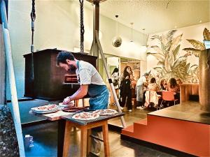 a man is making pizzas on a table at Avenue Hostel & Suites in Lisbon